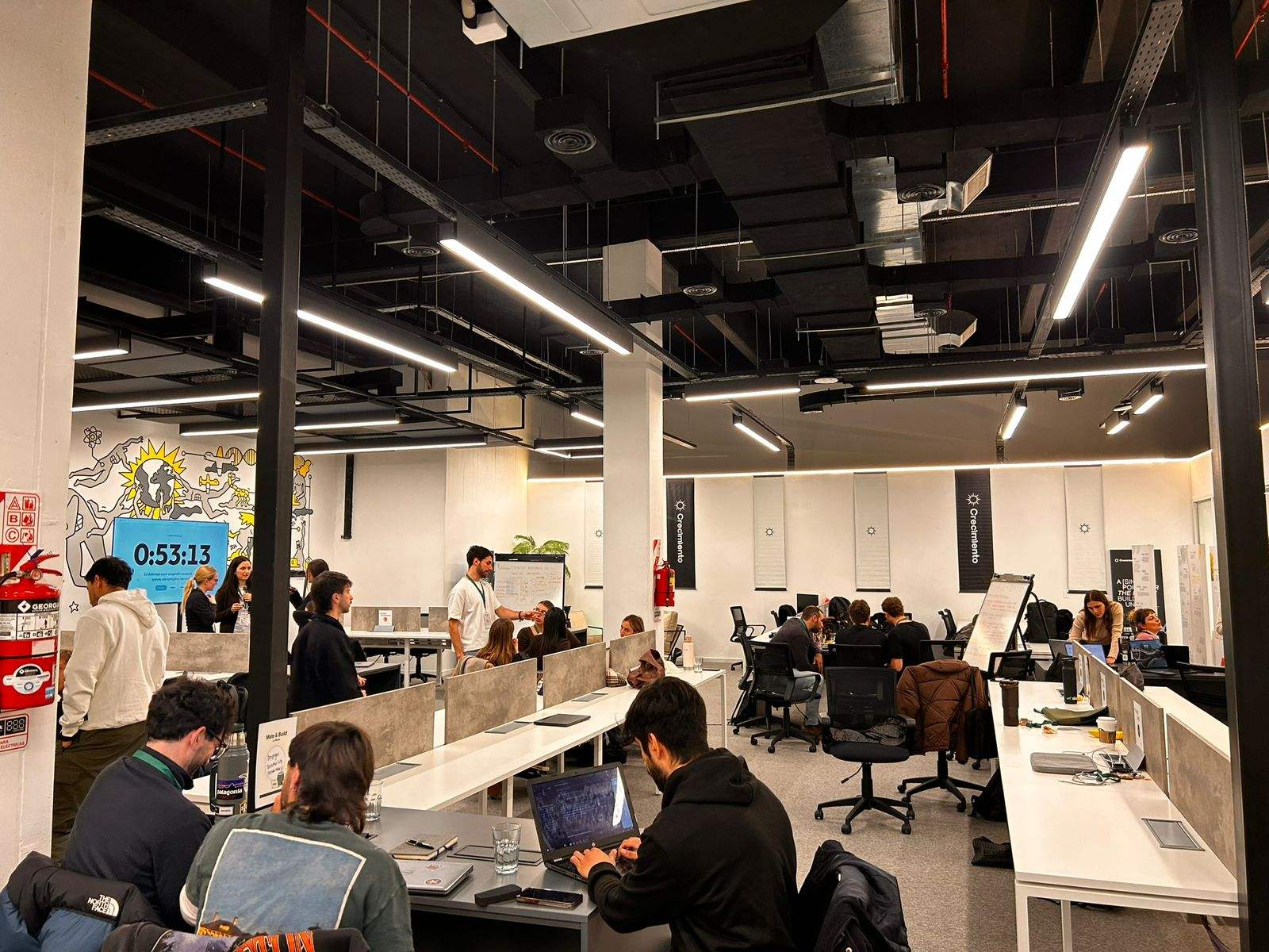 Una sala llena de equipos construyendo con IA en un buildathon